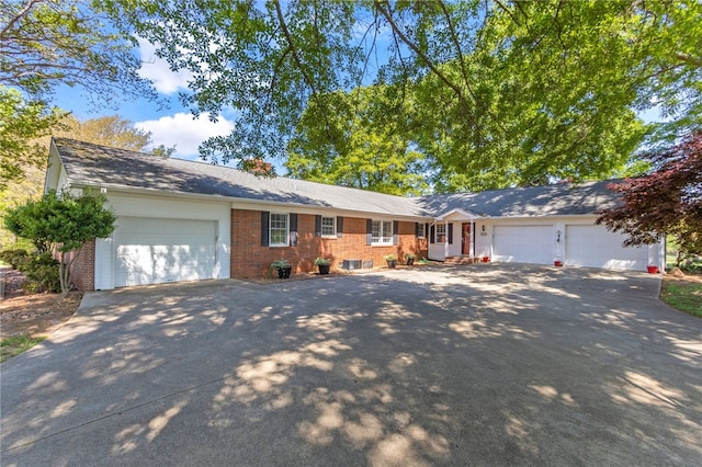 ranch-style house with a garage, brick siding, and driveway