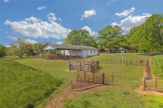 view of yard featuring an exterior structure, a rural view, and an outdoor structure