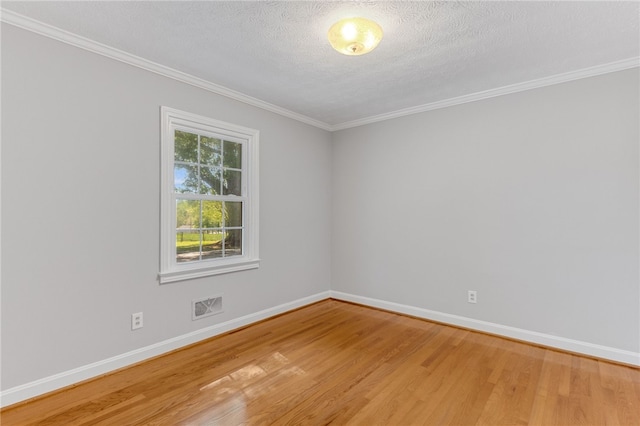 empty room featuring baseboards, a textured ceiling, visible vents, and wood finished floors