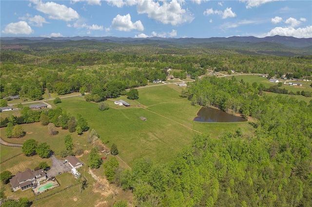 birds eye view of property featuring a forest view and a water and mountain view