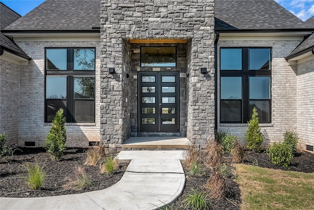 entrance to property featuring roof with shingles, brick siding, and crawl space