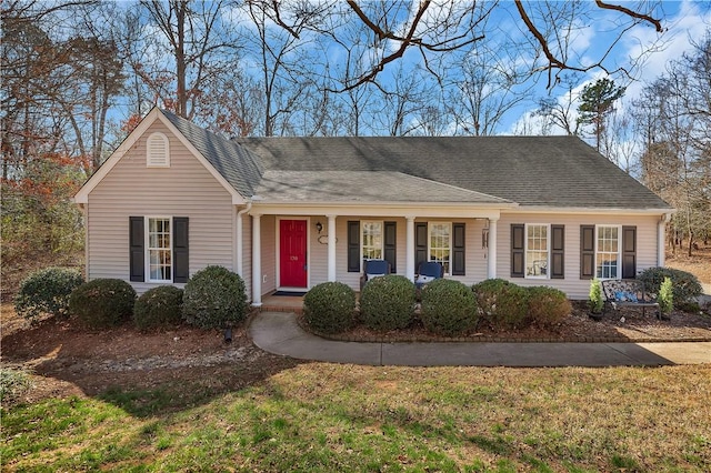 ranch-style home with a porch and roof with shingles