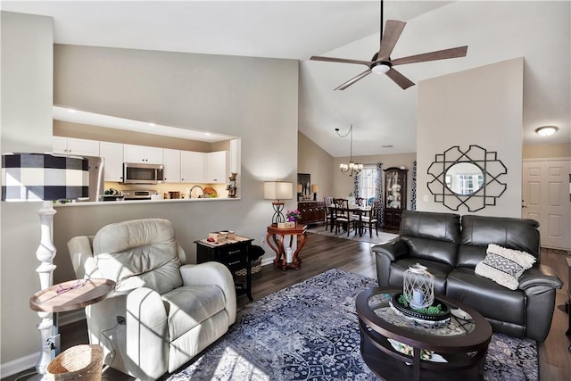 living room featuring high vaulted ceiling, ceiling fan with notable chandelier, baseboards, and wood finished floors