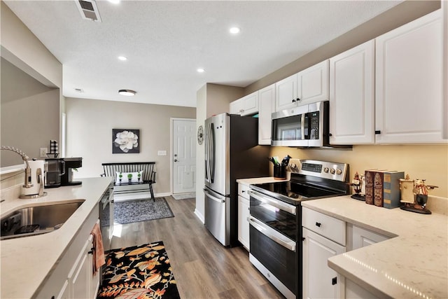 kitchen with white cabinetry, visible vents, appliances with stainless steel finishes, and a sink