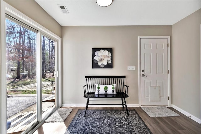 entryway featuring visible vents, baseboards, and wood finished floors