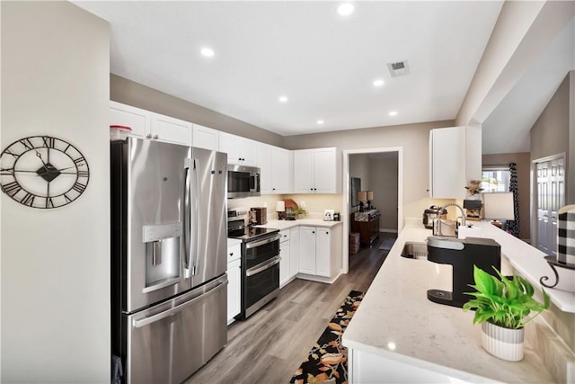 kitchen featuring recessed lighting, visible vents, appliances with stainless steel finishes, light wood-style floors, and a sink