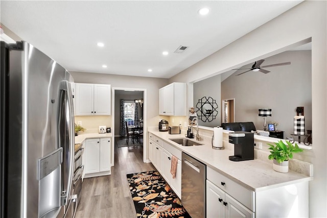 kitchen featuring appliances with stainless steel finishes, a sink, light wood-style flooring, and recessed lighting