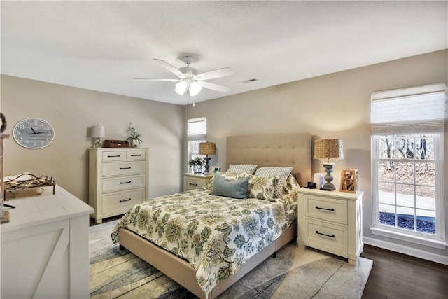 bedroom featuring light wood-style floors, ceiling fan, and visible vents