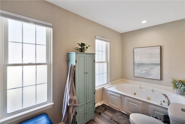 bathroom with a whirlpool tub, wood finished floors, and recessed lighting