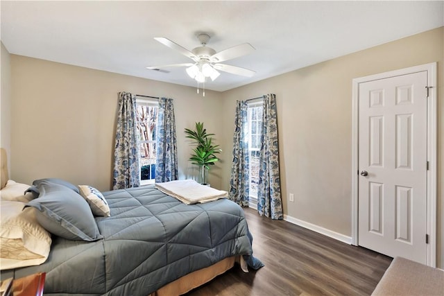 bedroom with a ceiling fan, dark wood-style flooring, and baseboards