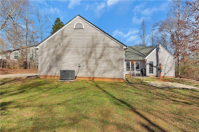 view of side of home featuring a yard, a patio, and central AC unit