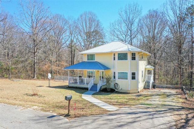 view of front of home with metal roof and a front yard