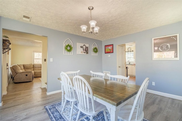 dining room with visible vents, baseboards, and wood finished floors