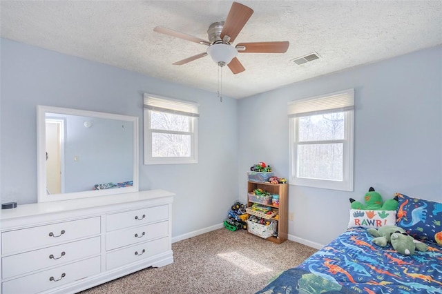 bedroom with a textured ceiling, multiple windows, visible vents, and carpet flooring