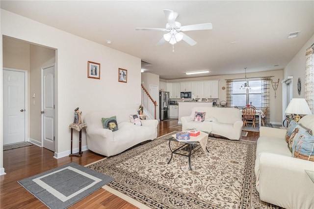 living room with visible vents, stairway, dark wood finished floors, and baseboards