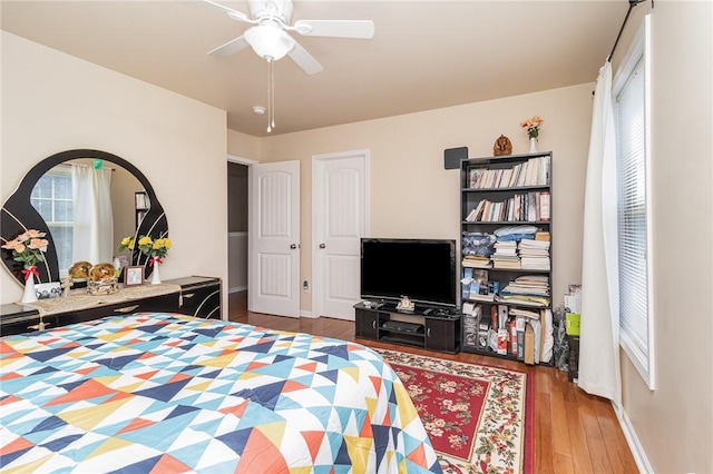 bedroom featuring a ceiling fan, baseboards, and wood finished floors