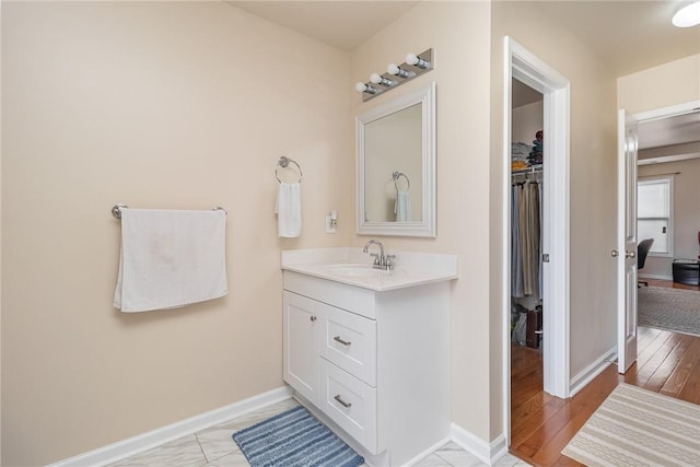 bathroom with vanity, baseboards, and wood finished floors