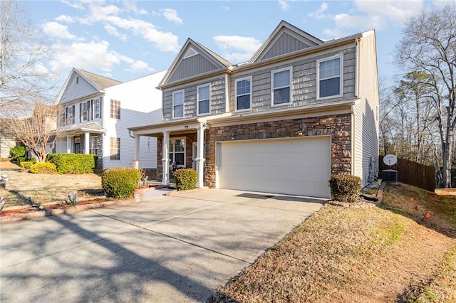 view of front of home with an attached garage, stone siding, board and batten siding, and concrete driveway