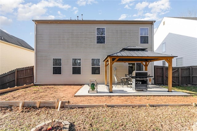 rear view of property featuring a fenced backyard, a patio, and a gazebo