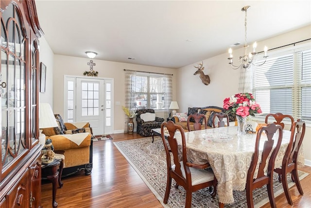 dining room with baseboards, wood finished floors, and a notable chandelier