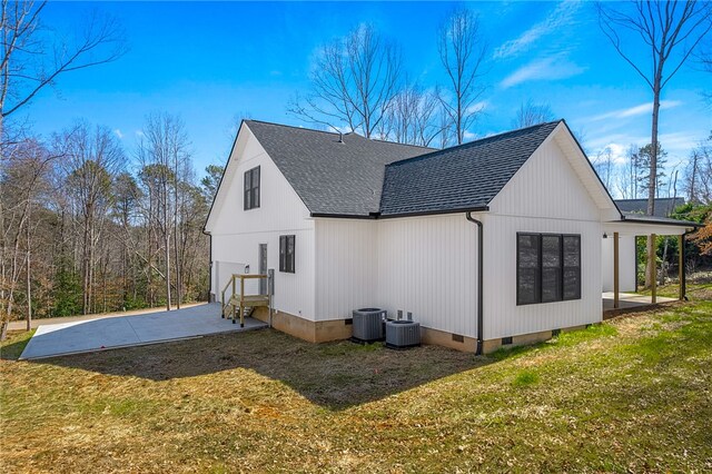 rear view of house featuring crawl space, central air condition unit, a shingled roof, and a yard