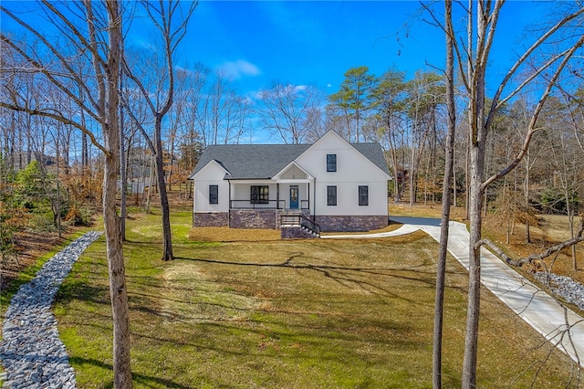 modern inspired farmhouse with concrete driveway, roof with shingles, and a front yard