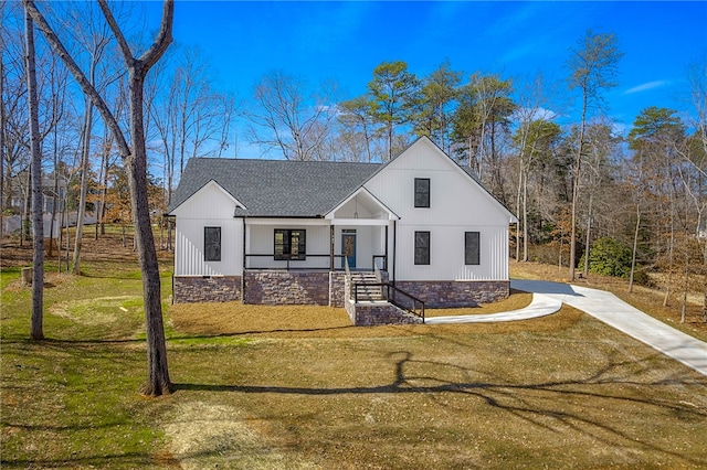 modern inspired farmhouse featuring a front lawn and roof with shingles