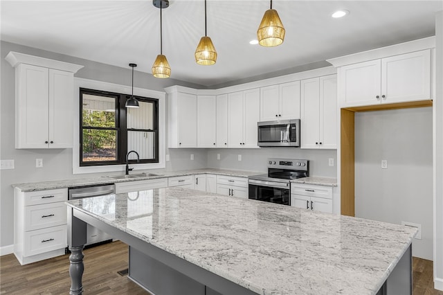 kitchen featuring appliances with stainless steel finishes, white cabinetry, a sink, and dark wood-type flooring