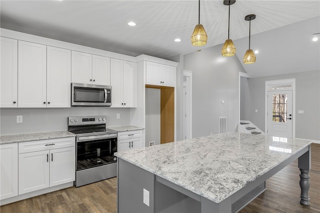 kitchen featuring stainless steel appliances, a kitchen island, white cabinetry, dark wood finished floors, and decorative light fixtures