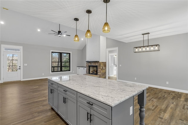 kitchen with dark wood finished floors, open floor plan, vaulted ceiling, gray cabinets, and a fireplace