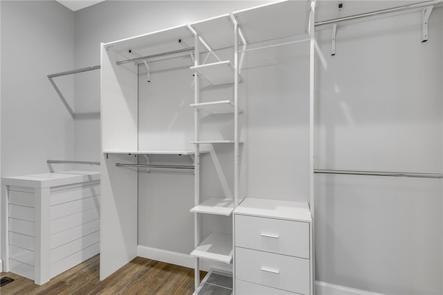 walk in closet with dark wood-type flooring