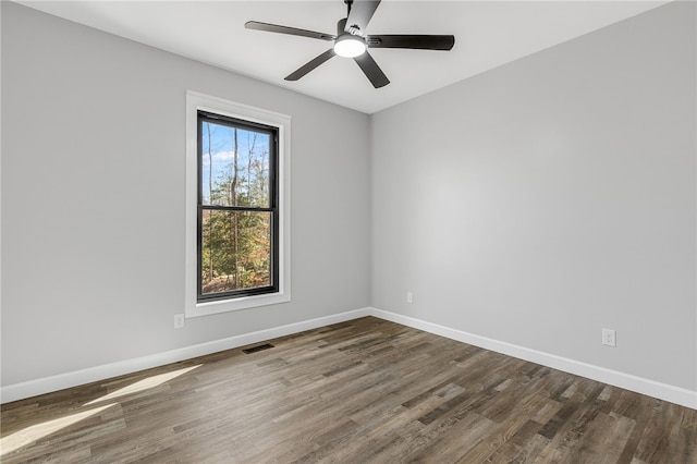 spare room with visible vents, ceiling fan, baseboards, and wood finished floors