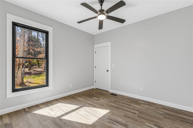 unfurnished room with a ceiling fan, baseboards, and wood finished floors