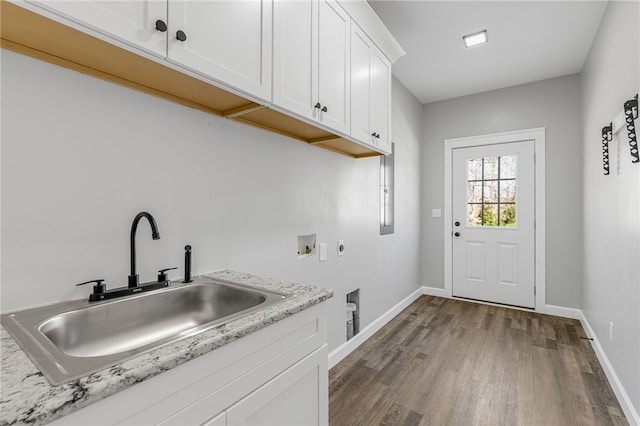 laundry room featuring cabinet space, dark wood-type flooring, hookup for a washing machine, hookup for an electric dryer, and a sink