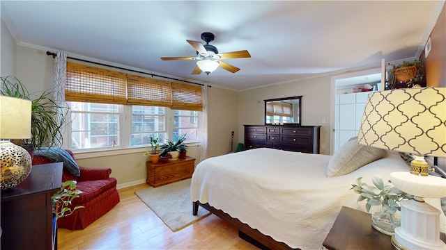 bedroom featuring baseboards, ceiling fan, ornamental molding, and wood finished floors