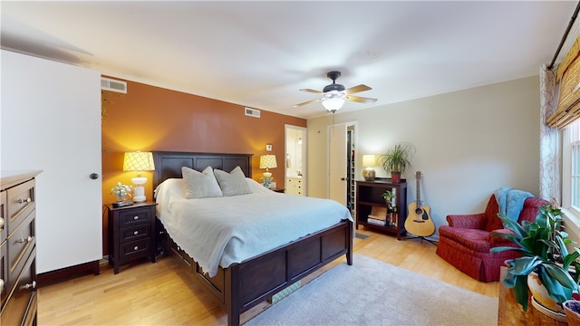 bedroom featuring light wood-style flooring, visible vents, and ceiling fan