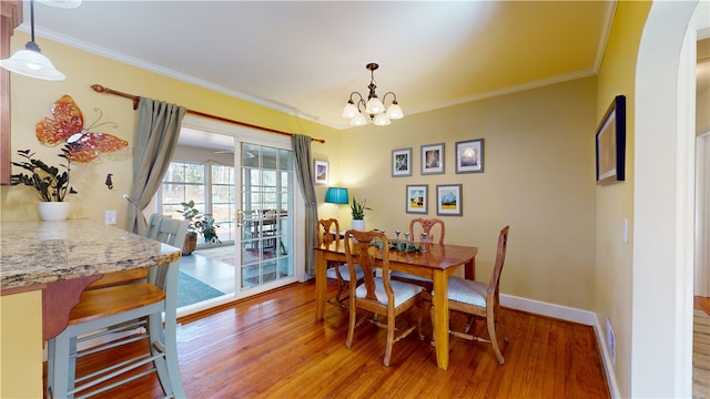 dining room featuring light wood-type flooring, baseboards, and ornamental molding