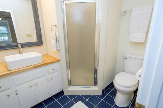 full bathroom featuring toilet, a shower stall, vanity, and tile patterned floors