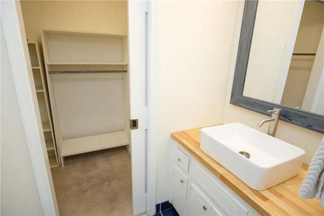 bathroom with a spacious closet and vanity