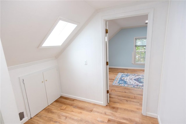 bonus room with light wood-style floors, baseboards, and lofted ceiling with skylight