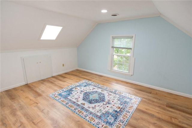 bonus room featuring visible vents, vaulted ceiling, baseboards, and wood finished floors