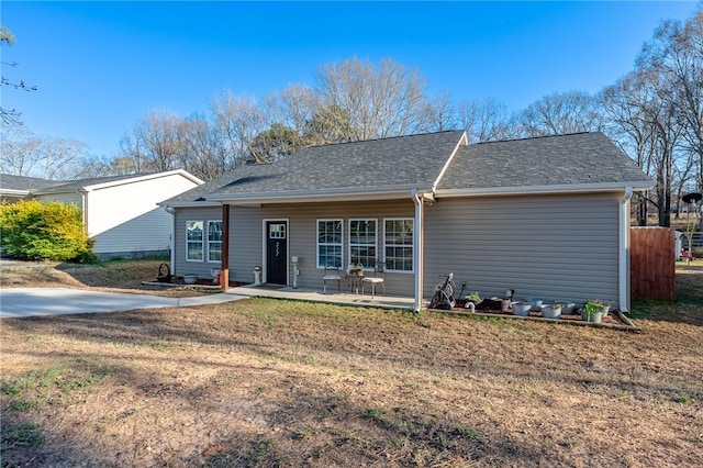 view of front of home featuring a shingled roof, a front yard, and fence