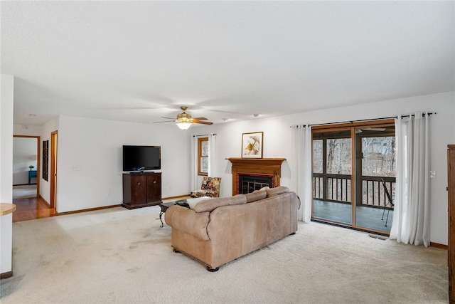 living area with a glass covered fireplace, carpet flooring, visible vents, and baseboards