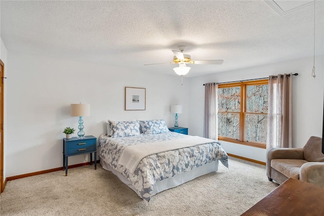 bedroom featuring a textured ceiling, ceiling fan, carpet flooring, baseboards, and attic access