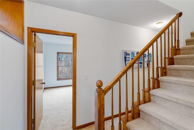 stairs featuring carpet floors and baseboards