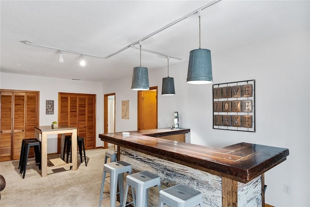 bar featuring rail lighting and light colored carpet