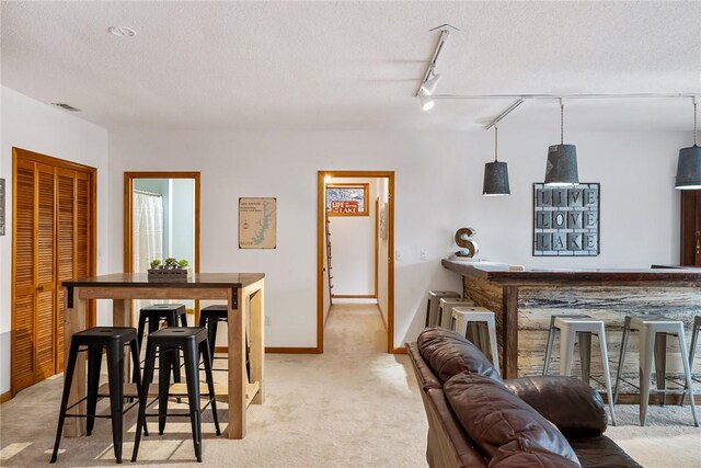 dining area with a textured ceiling, light carpet, visible vents, and baseboards