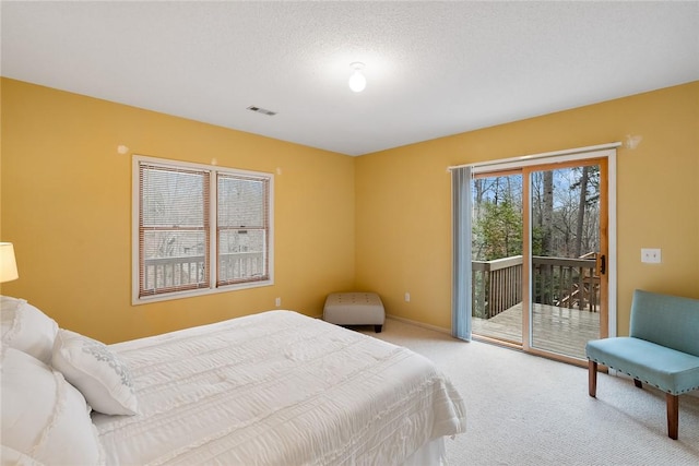 bedroom featuring access to exterior, visible vents, light colored carpet, a textured ceiling, and baseboards