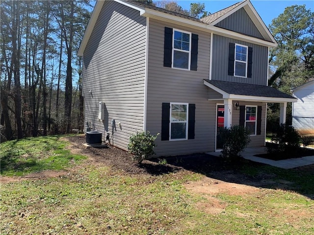 view of front of home featuring central AC and a front lawn