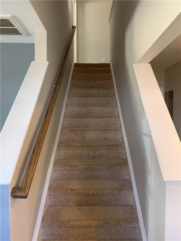 stairway featuring visible vents and baseboards